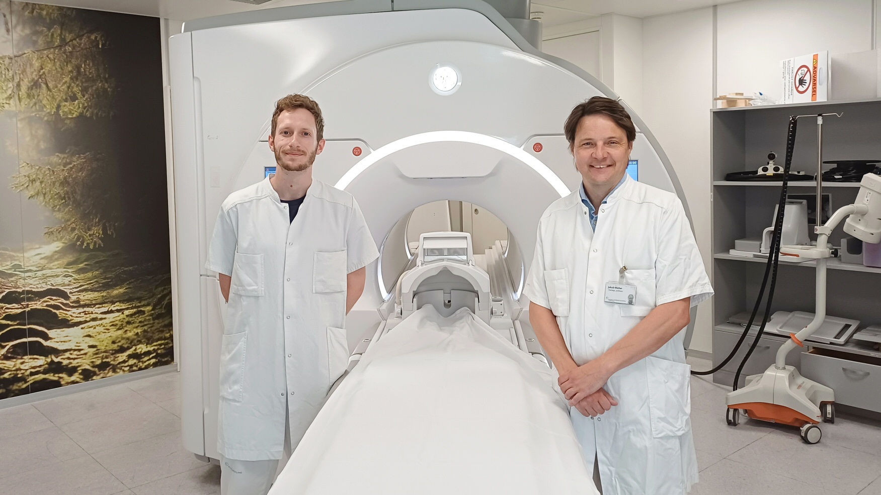 Lægerne Christian Holm Steenkjær (tv) og Jakob Blicher foran MR-skanneren på Radiologisk Afdeling.