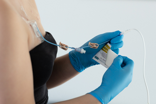 Foto af person, der desinficerer en samling mellem dropslange og gripperslange