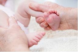 Picture of adult holding a baby's legs with a firm grip