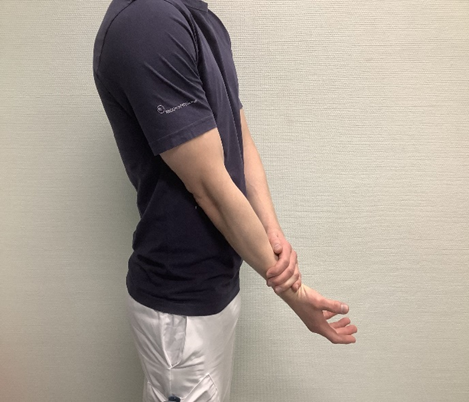 Foto af mand, der bruger sin ene arm til at gribe om den anden underarm. Form&aring;let er at illustrere &oslash;velsen, der ogs&aring; er beskrevet med ord.