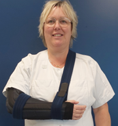Billede af kvinde med arm i bandage og armslynge.